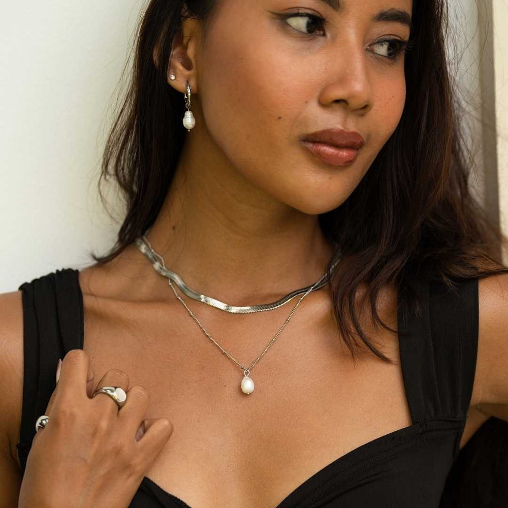 Woman wearing a matching gold waterproof jewellery set by Bay of Hayley