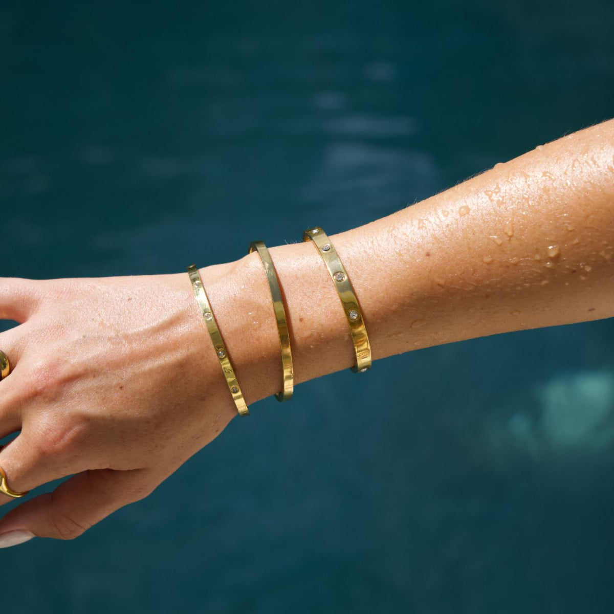 Gouden waterproof armbanden van Bay of Hayley bij het zwembad